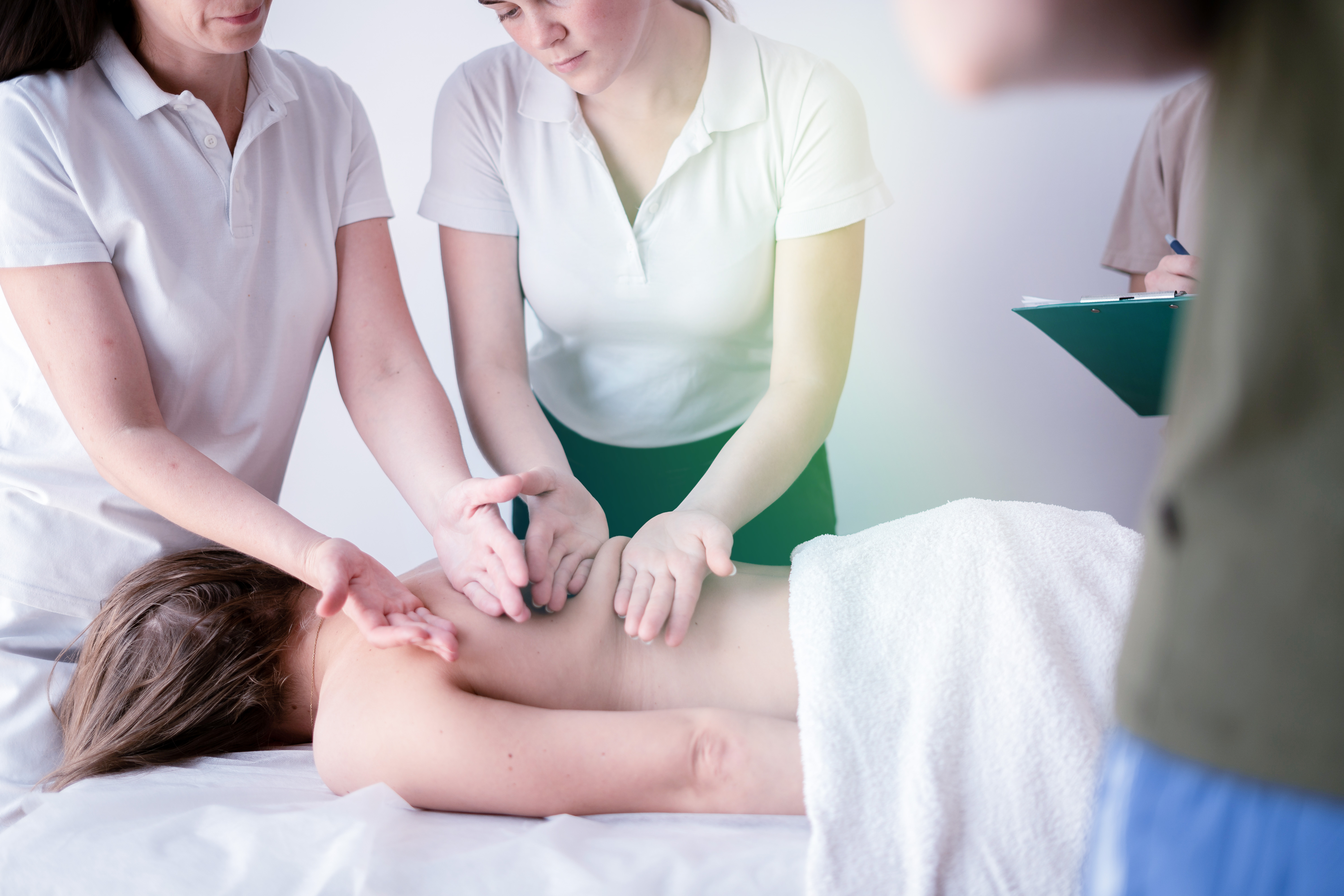 instructor works with a student learning massage
